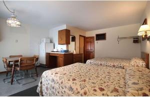 a hotel room with two beds and a table and a kitchen at Dolphyn Motel in Hampton