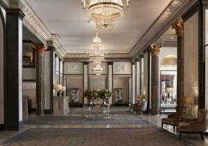 a lobby with a table and chairs and a chandelier at Grand Hôtel Stockholm in Stockholm