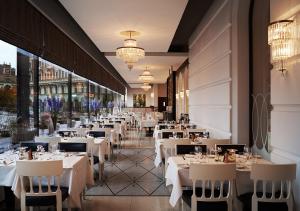 une salle à manger avec des tables et des chaises blanches dans l'établissement Grand Hôtel Stockholm, à Stockholm