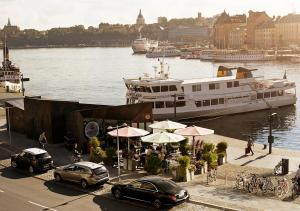 a boat is docked at a restaurant next to the water at Grand Hôtel Stockholm in Stockholm