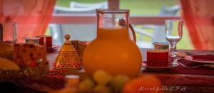 une carafe de verre de jus d'orange assise sur une table dans l'établissement Mer et Sable B&B, à Ville-Pommeroeul