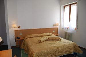 a bedroom with a large bed with a wooden headboard at Hotel Etruria in Orvieto