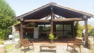 a wooden pavilion with chairs and a table at La Dolce Vita Country House with pool - Solicchiata in Castiglione di Sicilia