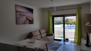ein Wohnzimmer mit einem Sofa und einem Tisch in der Unterkunft Vista das Ondas Olhos de Agua in Albufeira