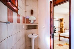 a bathroom with a sink and a mirror at Casa Cumbuco e Hospedaria in Cumbuco
