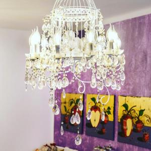 um lustre num quarto com uma parede roxa em Hotel Porta Marmorea em Gubbio