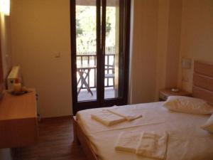 オマロスにあるSamaria Villageのベッドルーム1室(ベッド1台、タオル2枚付)