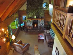 vistas panorámicas a una sala de estar con chimenea de piedra en Kohala Lodge- Vacation Rental House, en Hawi