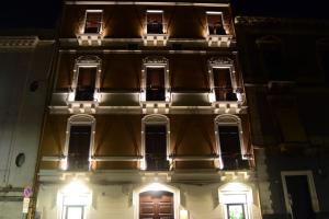 a building with lights on the front at night at Hotel Centrum in Catania