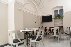 a dining room with tables and chairs and a flat screen tv at Hotel Centrum in Catania