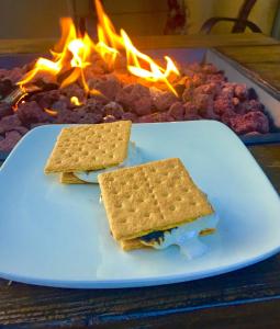 a plate with two crackers on a table with a fire at Rest, a boutique hotel in Plymouth