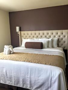 1 dormitorio con 1 cama grande con sábanas y almohadas blancas en Rest, a boutique hotel, en Plymouth