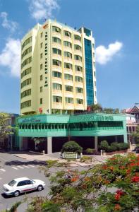 a white car parked in front of a large building at Bamboo Green Central Hotel in Da Nang