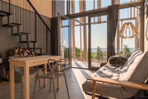 a living room with a table and a large window at Weinloft II by WEINLOFTS in Eisenberg an der Pinka