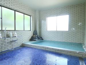 a bathroom with a large tub with a window at Suimeiso in Yamanakako