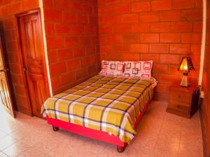 a small bed in a room with a red brick wall at Sol de Playa in Playas