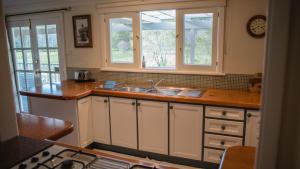 a kitchen with a sink and two windows at Parkfarm Views in Albany