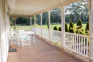 a white porch with a table and chairs on it at Parkfarm Views in Albany