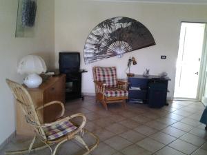 a living room with a tv and a chair and a table at Appartamento Arenella in Arenella