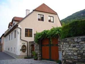 ein Haus mit einer Garage und einer Steinmauer in der Unterkunft Gästehaus Schütz in Spitz