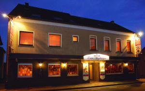 un edificio con una tienda en una calle por la noche en Gasthof zum Siegburger, en Straelen