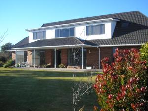 een stenen huis met een zwart dak bij Amberlea B&B in Hokitika
