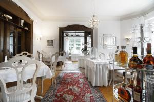 uma sala de jantar com mesas brancas e cadeiras brancas em Höhen Hotel Viersen em Viersen