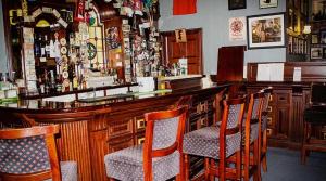 a bar with wooden chairs and a bar top at Round Tower Hotel in Ardmore