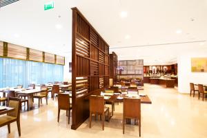 a restaurant with tables and chairs in a room at Holiday Bahrain Hotel in Manama