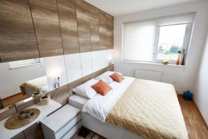 ein Schlafzimmer mit einem großen Bett und einem Fenster in der Unterkunft Apartments Panamera in Sarajevo