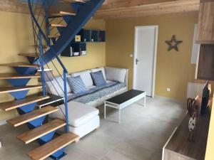 ein Wohnzimmer mit einer Treppe und einer Couch in der Unterkunft Appartement en bord de Mer in Saintes-Maries-de-la-Mer