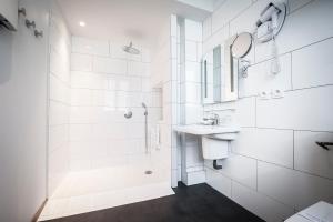 a white bathroom with a sink and a shower at The Originals Boutique, Hôtel Auberge du Forgeron, Lille Sud in Seclin +67 photos