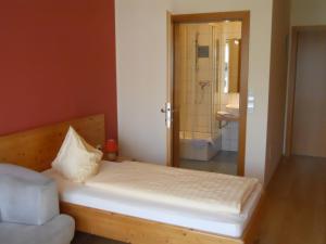 een slaapkamer met een bed en een badkamer met een douche bij Gästehaus Ehweiner in Pöls