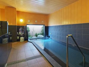 een groot zwembad in een kamer met een zwembad bij Hotel Route Inn Hitachinaka in Hitachinaka