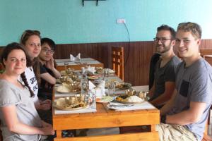 um grupo de pessoas sentadas à volta de uma mesa com comida em Everest Holiday Inn em Kathmandu