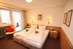 Rúm í herbergi á Hotel Adler Garni