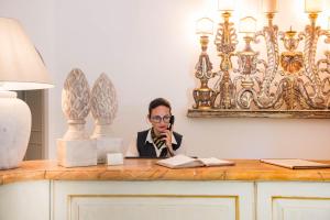 a man sitting at a desk talking on a phone at Castello di San Marco Charming Hotel & SPA in Calatabiano +83 photos
