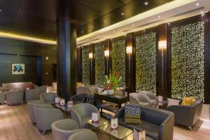 a restaurant with white chairs and tables and windows at Le Corail Suites Hotel in Tunis