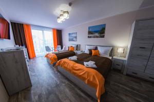 1 dormitorio con 2 camas con sábanas de color naranja en Villa Lamar, en Międzyzdroje