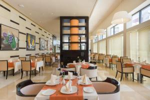 a restaurant with tables and chairs in a room at Le Corail Suites Hotel in Tunis