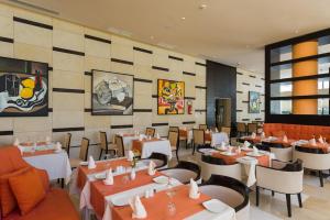 a restaurant with tables and chairs in a room at Le Corail Suites Hotel in Tunis