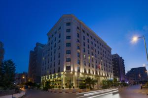 a tall white building with lights in a city at Le Corail Suites Hotel in Tunis