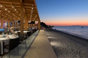 a restaurant on the beach at sunset at Avra Beach Resort in Ixia