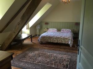a bedroom with a bed and a table in a attic at Château Ville Voisin in Augan