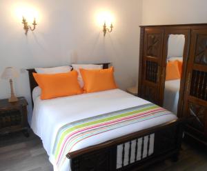 a bedroom with a bed with orange pillows at Hôtel Camou in Uhart-Cize