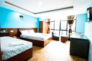 a hotel room with two beds and a blue wall at Everest Holiday Inn in Kathmandu