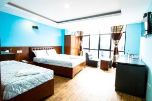 um quarto de hotel com duas camas e uma parede azul em Everest Holiday Inn em Kathmandu