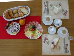 una mesa con platos de comida y tazas de café en B & B Hartenfels 73, en Lucerna