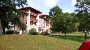 a building with a park in front of it at Appartement dans résidence de vacances in Biscarrosse