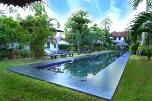a swimming pool in a yard next to a house at Turtle Eco Beach in Matara
